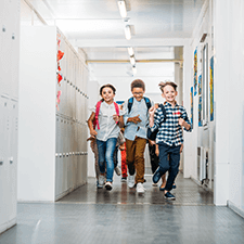 smiling children running in a school hallway 