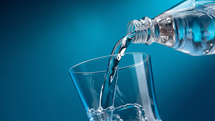 water pouring into a glass. Some water bottles have been found to contain hand sanitizer.